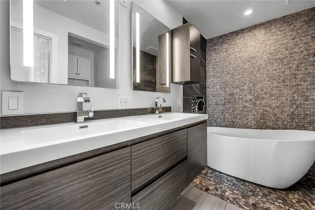 bathroom with a bathing tub, hardwood / wood-style floors, and vanity