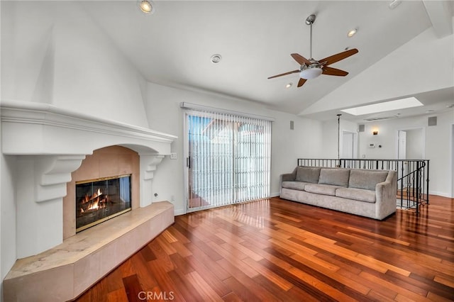 living room featuring wood-type flooring, high vaulted ceiling, ceiling fan, and a fireplace