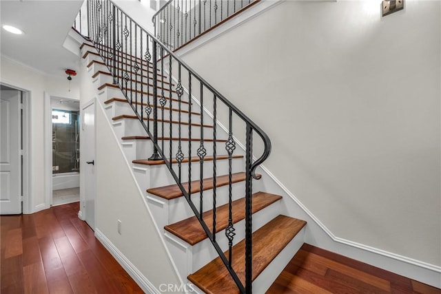 staircase with crown molding, recessed lighting, wood finished floors, and baseboards