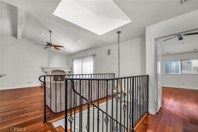 hall with dark hardwood / wood-style flooring, vaulted ceiling with beams, and an inviting chandelier