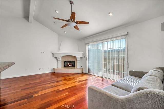 living room with hardwood / wood-style floors, vaulted ceiling with beams, a large fireplace, and ceiling fan