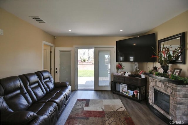 living area featuring a fireplace, visible vents, wood finished floors, and recessed lighting