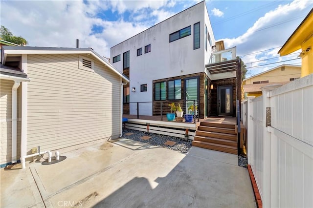 back of property with a deck and a patio area