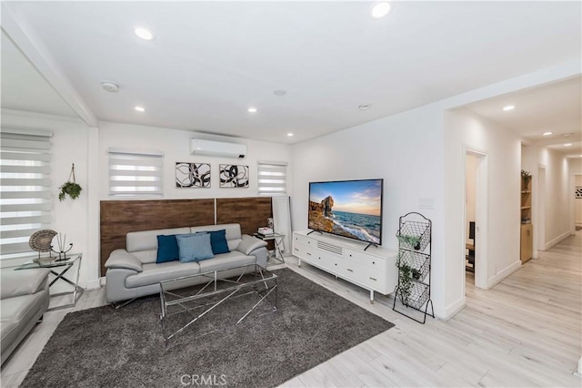 living room featuring a wall mounted AC and light hardwood / wood-style flooring