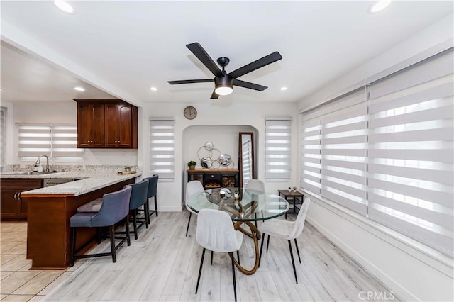 dining room with a healthy amount of sunlight, sink, ceiling fan, and light hardwood / wood-style flooring