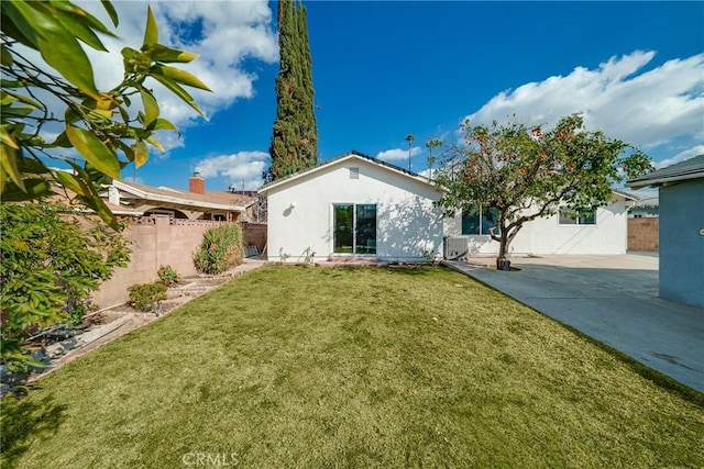 back of property featuring a yard and a patio area