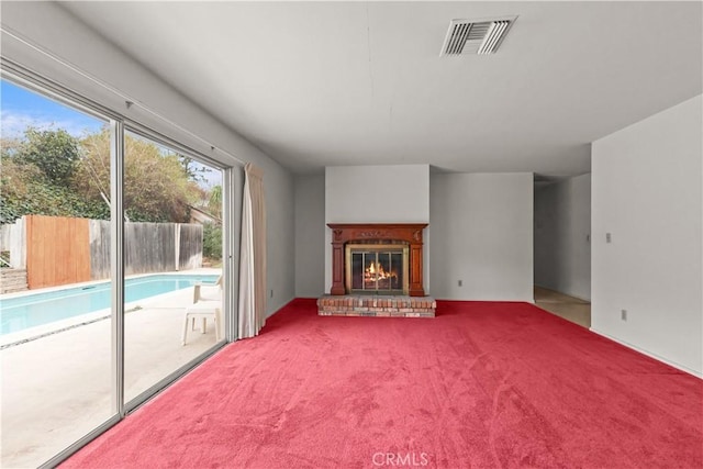 unfurnished living room with a fireplace and carpet