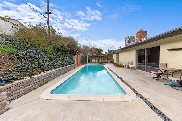 view of pool featuring central air condition unit and a patio area