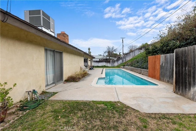 view of swimming pool with a lawn, a patio, and central air condition unit