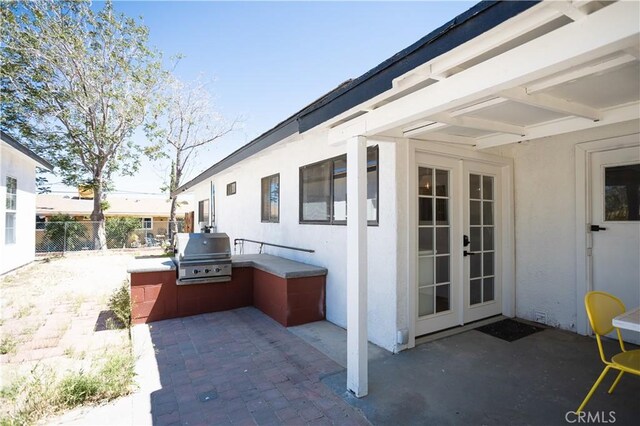 view of patio featuring exterior kitchen, french doors, area for grilling, and fence