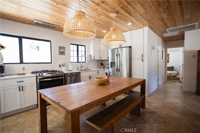 kitchen with white cabinets, light countertops, visible vents, wood ceiling, and appliances with stainless steel finishes