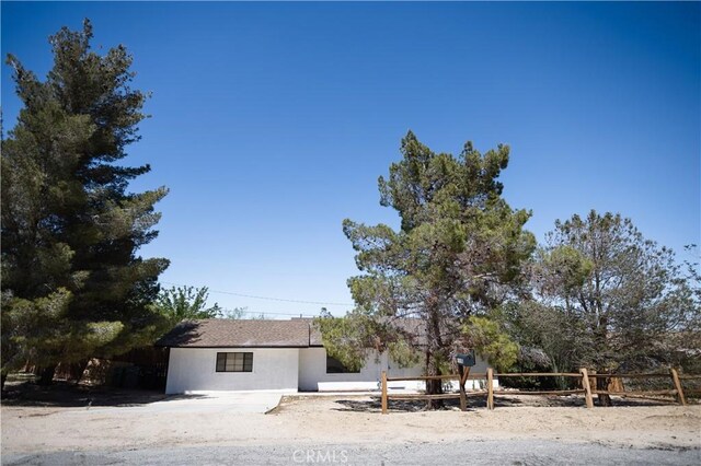 view of front of property featuring stucco siding and fence