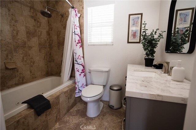 bathroom featuring tiled shower / bath combo, toilet, and vanity