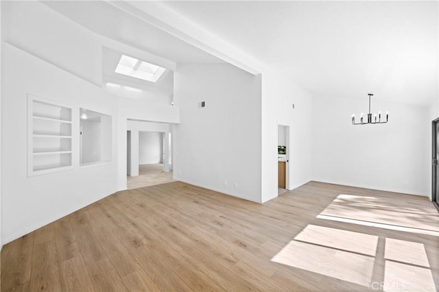 unfurnished living room with an inviting chandelier, built in features, vaulted ceiling, and light wood finished floors