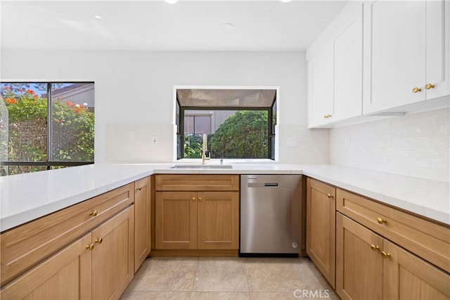 kitchen featuring plenty of natural light, light countertops, dishwasher, and a sink