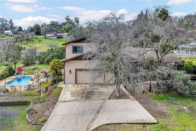 exterior space with a garage and a fenced in pool