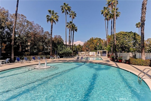community pool with fence and a patio
