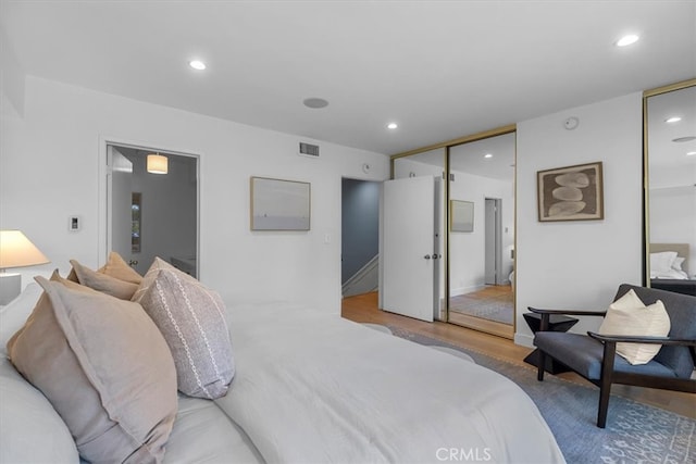 bedroom with recessed lighting, wood finished floors, and visible vents