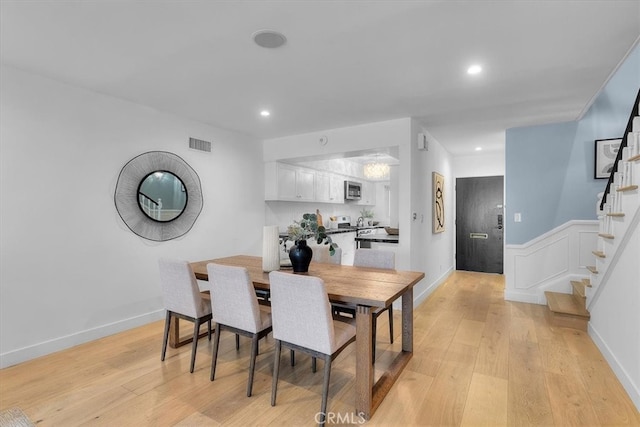 dining room with light wood finished floors, stairs, visible vents, and recessed lighting