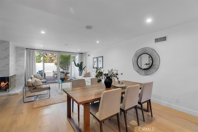 dining area with light wood-style flooring, visible vents, and recessed lighting
