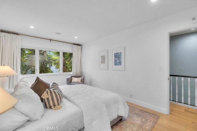 bedroom with recessed lighting, light wood-style floors, and baseboards