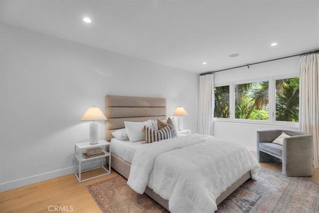 bedroom with baseboards, wood finished floors, and recessed lighting