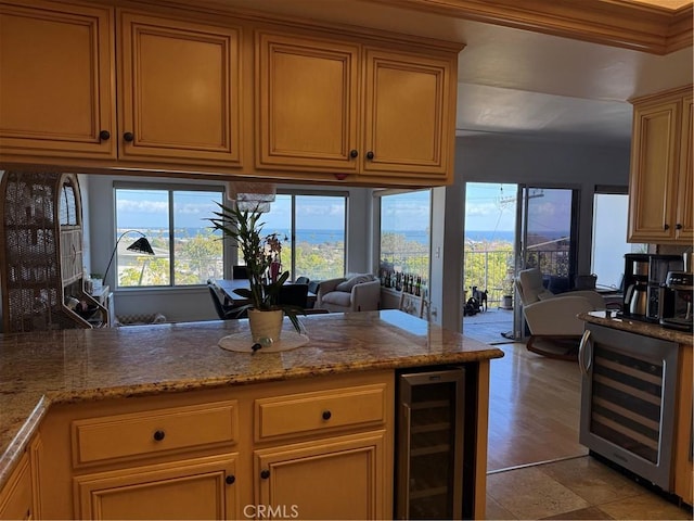 kitchen featuring wine cooler and light stone counters