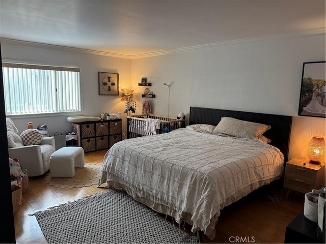 bedroom with ornamental molding and light hardwood / wood-style flooring