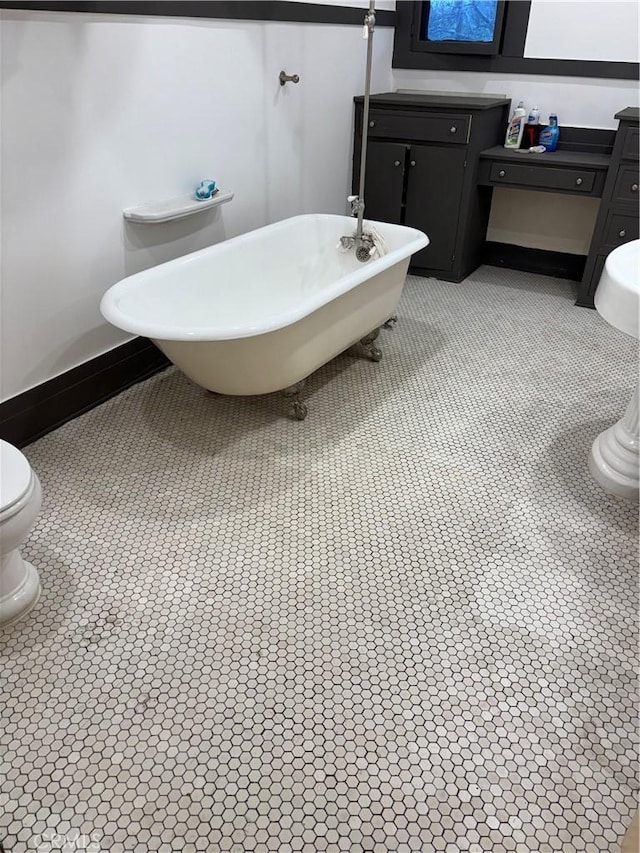 bathroom featuring vanity, toilet, and a tub