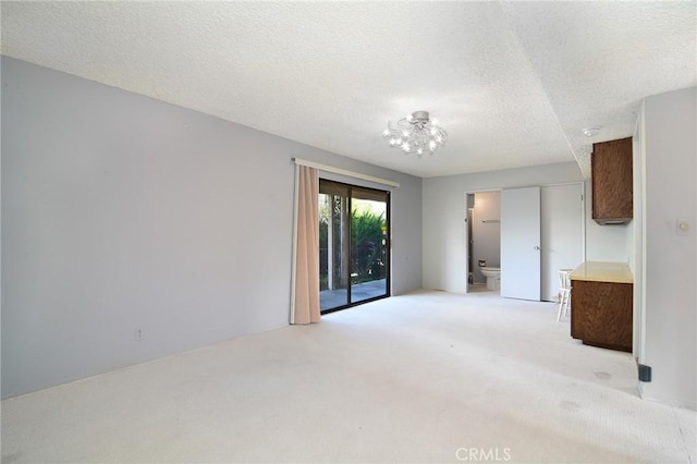 carpeted empty room featuring a textured ceiling