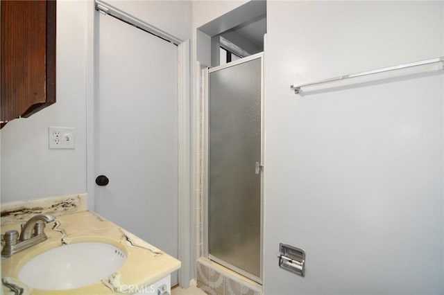 bathroom with vanity and a shower with door