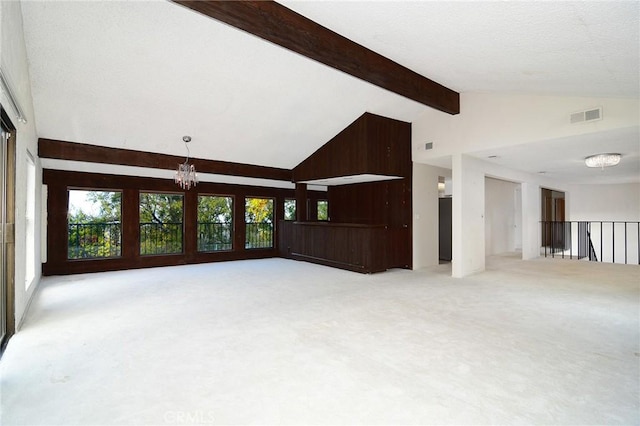 empty room with beam ceiling, a chandelier, high vaulted ceiling, and light carpet