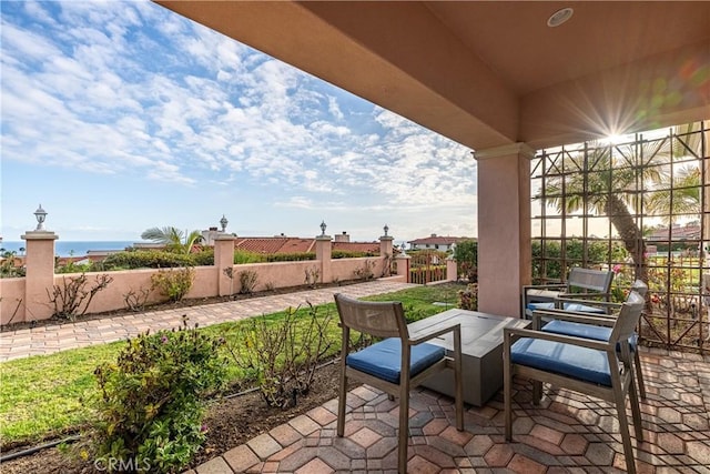 view of patio featuring a water view and fence private yard