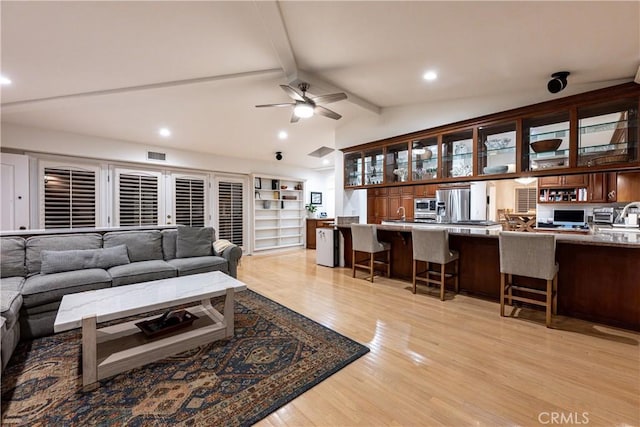 living area with visible vents, a ceiling fan, lofted ceiling with beams, light wood-style floors, and recessed lighting