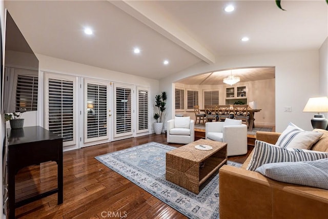 living area with lofted ceiling with beams, arched walkways, recessed lighting, wood finished floors, and baseboards