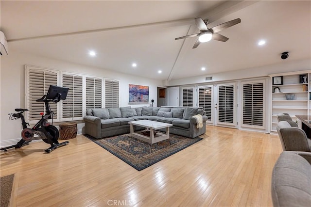 living area with ceiling fan, high vaulted ceiling, visible vents, an AC wall unit, and light wood-type flooring