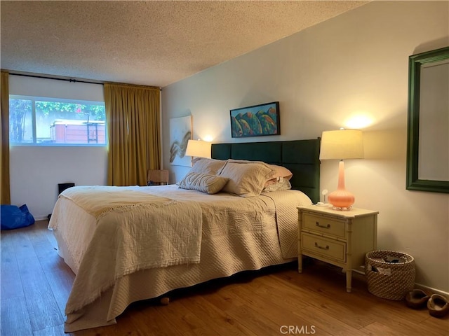 bedroom featuring a textured ceiling and light wood-type flooring