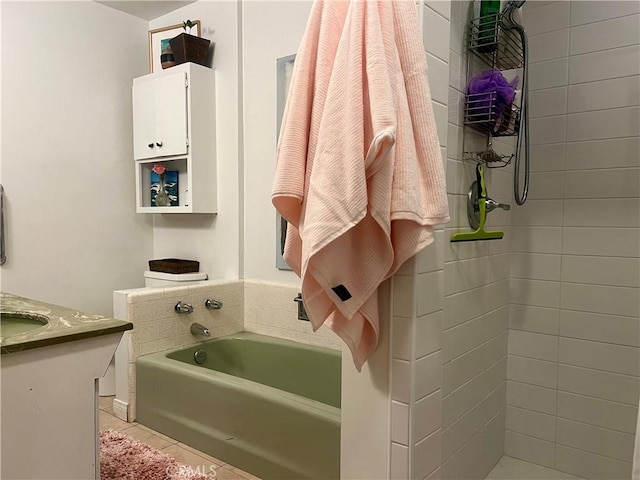 bathroom featuring tile patterned flooring, vanity, and a tub