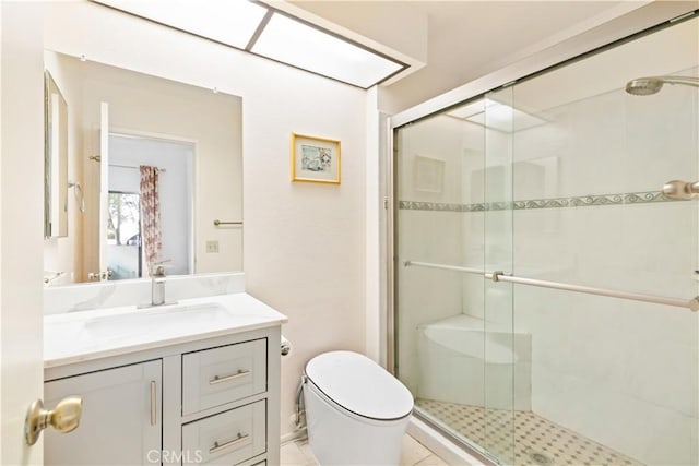 bathroom featuring vanity, toilet, and a shower with shower door