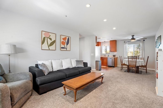 carpeted living room featuring sink and ceiling fan