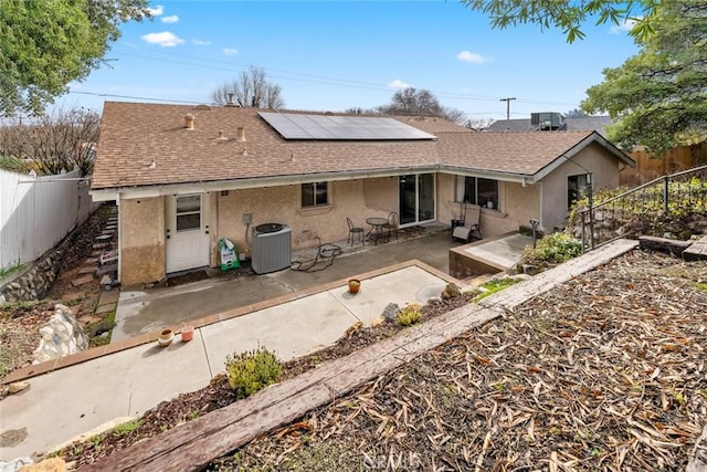 back of house featuring a patio, solar panels, and central air condition unit