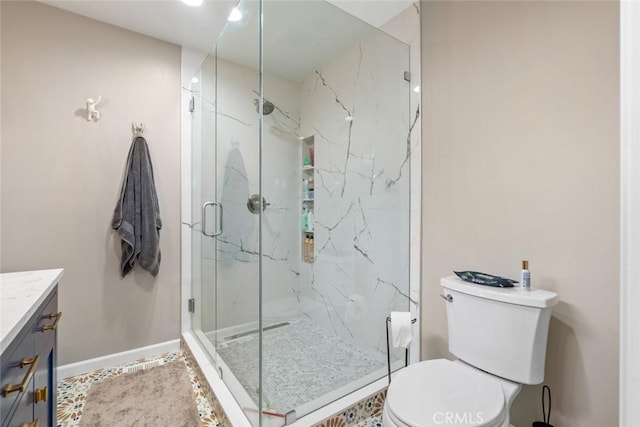 bathroom featuring vanity, a shower with shower door, and toilet