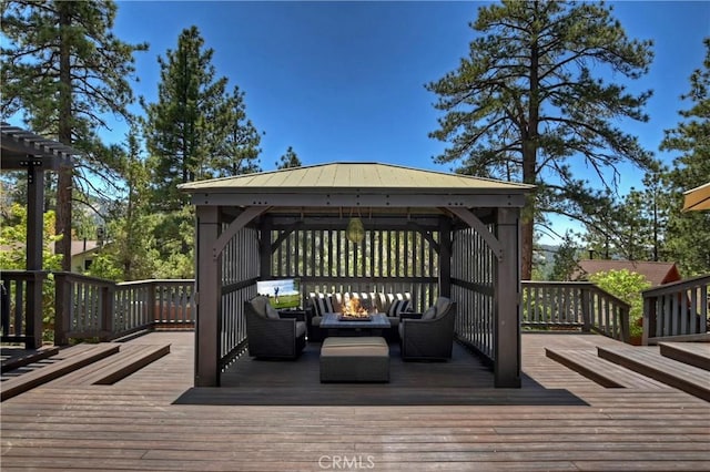 wooden deck featuring a gazebo and an outdoor living space with a fire pit