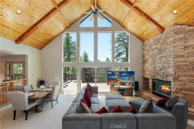 living room with wood ceiling, high vaulted ceiling, a fireplace, carpet floors, and beamed ceiling