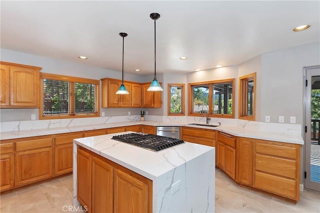 kitchen with a healthy amount of sunlight, decorative light fixtures, sink, and a kitchen island