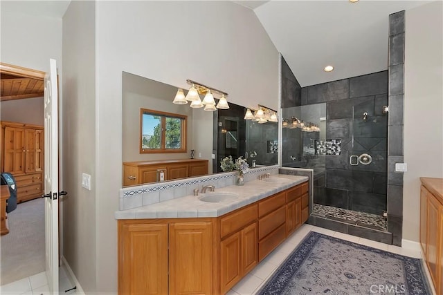 bathroom featuring tile patterned floors, lofted ceiling, vanity, and a tile shower