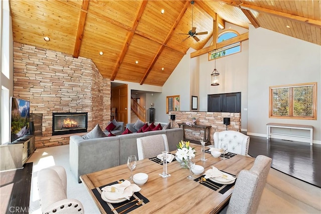 dining room with wood ceiling, beam ceiling, high vaulted ceiling, a fireplace, and wood-type flooring