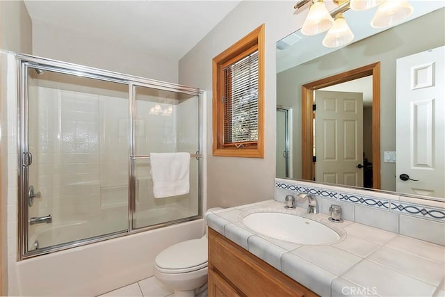 full bathroom featuring vanity, toilet, and combined bath / shower with glass door