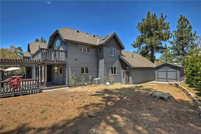 rear view of property with a wooden deck, a pergola, a shed, and central air condition unit