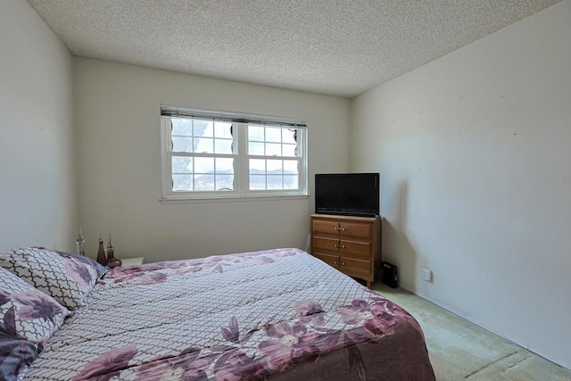 bedroom featuring light colored carpet and a textured ceiling